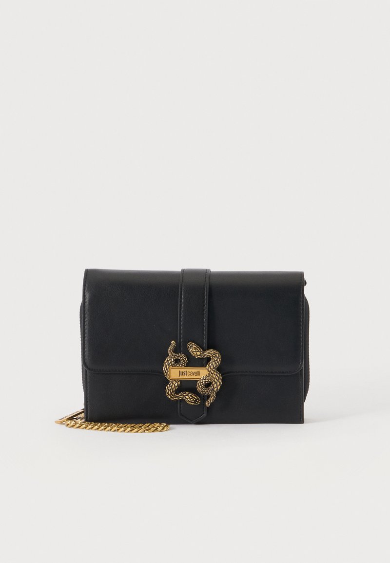 Μαύρο δερμάτινο τσαντάκι clutch με χρυσό στριφογυριστό κούμπωμα σε σχήμα φιδιού και αλυσίδα, επώνυμο Just Cavalli, σε απλό ανοιχτό φόντο.