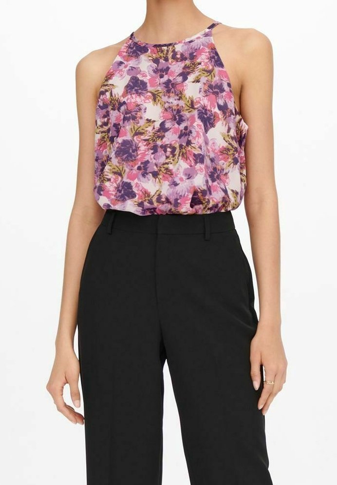 Blusa floral de tela ligera y transparente con flores moradas y rosas, combinada con pantalones negros de cintura alta.
