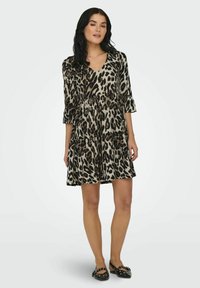 Robe imprimé léopard avec un décolleté en V, des manches trois-quarts et un design en couches. Fabriquée en tissu doux, présentant des tons noir et beige.