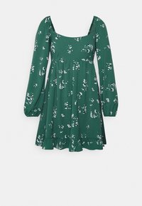 Vestido floral verde con escote cuadrado, mangas largas abullonadas y falda acampanada con dobladillo con volantes. Presenta un patrón de flores blancas en toda la prenda.