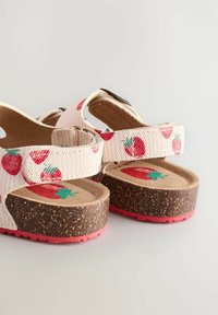 Erdbeer-musterte Sandalen mit einem weißen Obermaterial aus Canvas, einer Kork-Zwischensohle und einer pinken Gummisohle; ausgestattet mit verstellbaren Riemen für eine optimale Passform.