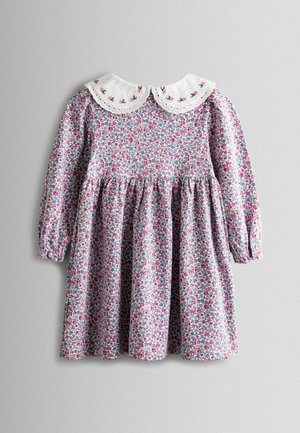 Oblačilo z dolgimi rokavi s cvetličnim vzorcem, z zbranim pasom in belim ovratnikom, ki ima pisan cvetlični vezen in čipkast rob.