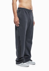 Grijze sweatpants met een elastische tailleband, zijzakken en een zwarte streep langs de pijpen. Lichtgewicht, met een ontspannen pasvorm.