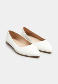 Białe płaskie buty z wąskim noskiem, wykonane z gładkiego materiału. Wnętrze jest beżowe, z smukłą sylwetką i minimalistycznym designem.