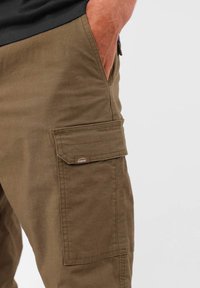 Pantalons cargo verts olive en tissu mélangé de coton, dotés de poches latérales, d'une poche à rabat et d'une petite étiquette de marque à l'avant.