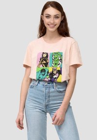 Vaaleanpunainen puuvillapaita, jossa on neliömäinen sarjakuva printti eri supersankarihahmoista voimakkaissa väreissä. Lyhyet hihat ja rento malli.