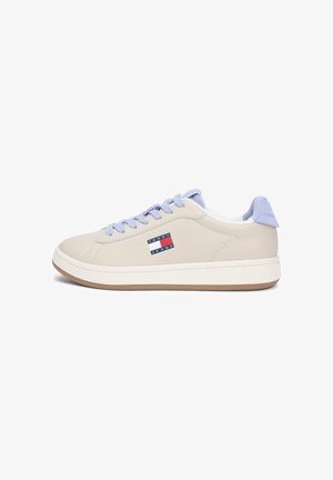 Low-top beige sneaker with light purple laces and heel tab, white sole, and Tommy Jeans logo on the side.