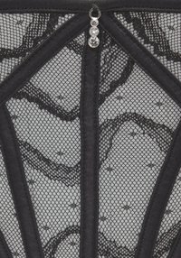 Black lace fabric featuring geometric patterns, structured panels, and decorative crystals. Textured appearance with fine detail and contrast elements.