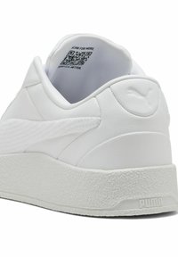 White leather sneaker with textured heel and rubber sole. Features a subtle logo and QR code on the inner ankle collar.