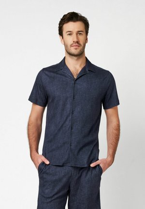 Kurzärmliges Hemd mit Knopfleiste aus dunkelblauem Denim. Kragen-Design mit subtiler Textur und geradem Saum. Glatter Stoff mit lässiger Passform.
