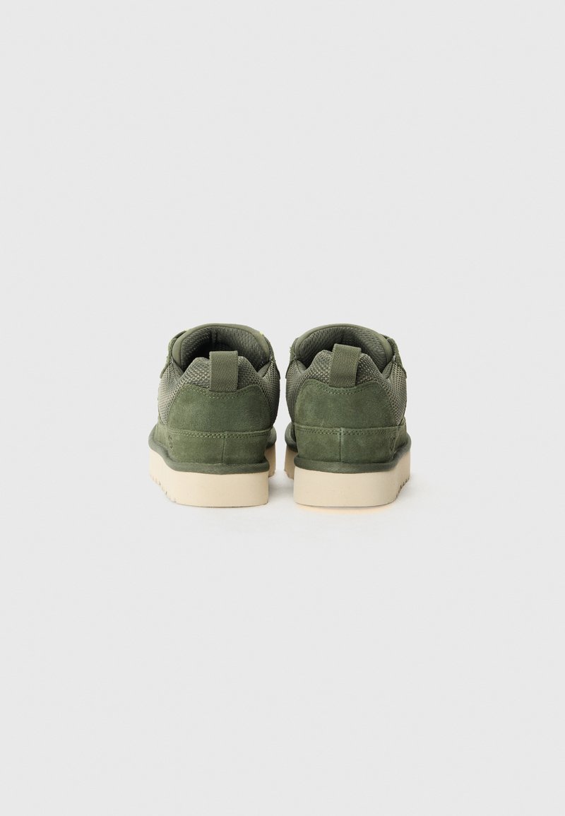 Zielone zamszowe sneakersy z siateczki o niskim profilu, z teksturowaną cholewką, wzmocnionym piętą i beżową gumową podeszwą. Pokazany widok z tyłu.
