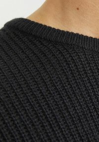 Black ribbed knit fabric with a round neckline, showcasing a textured pattern and soft appearance. Close-up view of the material.