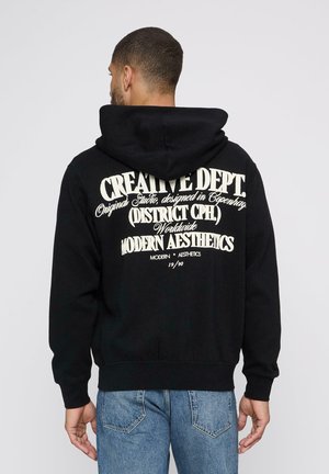 Black hoodie with a large white graphic on the back, featuring text in various fonts. Made from a soft fabric with a relaxed fit.