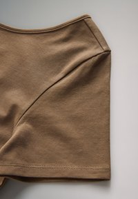 Pruun puuvillane kangas, millel on kaarjas õmblusdisain ja sile tekstuur, lihtsa äärega ning ümar kaelus.