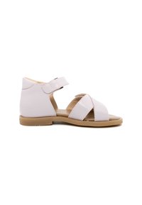 Sandalo in pelle rosa con cinturino in Velcro, suola piatta beige, design aperto sulla punta e dettagli incrociati sulla parte anteriore.