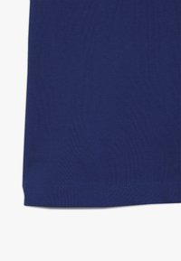 Blå texturerad tyg med en fin väv, som har en rak fåll. Materialet verkar vara lättviktigt och lämpligt för avslappnad klädsel.