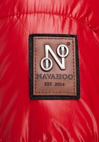 Czerwona kurtka puchowa z brązowym skórzanym naszywką z wytłoczonym logo "NAVAHOO" i "EST 2014", na błyszczącej czerwonej tkaninie.
