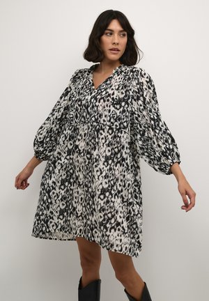 Schwarz-weiß gemustertes Kleid mit V-Ausschnitt, Ballonärmeln und lockerer Passform, aus leichtem Stoff gefertigt.