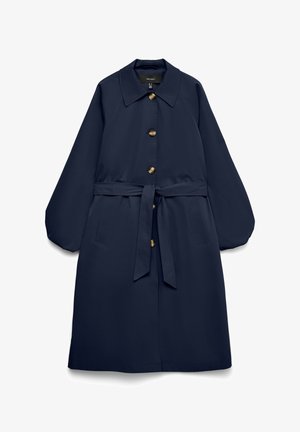 Palton lung bleumarin cu nasturi mari, talie cu curea, guler larg, buzunare laterale înclinate și mâneci lungi în stil balon.