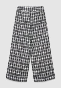 Pantalon à jambes larges à carreaux noir et blanc avec une taille élastique, présentant une texture tissée et de subtils accents métalliques sur l'ensemble.