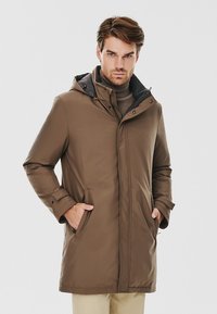 Brązowy wodoodporny parka z kapturem, z szarym wyłożonym kołnierzem, przednimi zapięciami na napy i bocznymi kieszeniami. Gładka tekstura, ciepły fason.