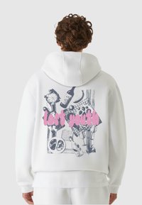 Hvit hettegenser med grafisk design på baksiden, med ulike illustrasjoner av flasker og mat, samt teksten "lost youth" i rosa.