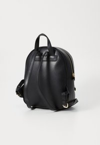 Sac à dos en cuir noir au design arrondi, accents en métal doré, doubles poignées supérieures et bretelles réglables. Texture lisse.