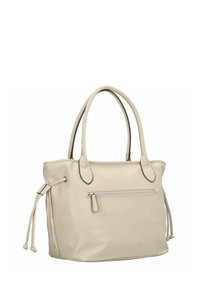 Sac fourre-tout en cuir beige avec deux poignées supérieures, compartiment principal zippé et poche zippée extérieure. Présente des détails à cordon de serrage sur les côtés.