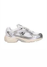 Chaussure de sport New Balance blanche et argentée avec des panneaux en mesh, une fermeture à lacets et une semelle beige coussinée, vue de côté.