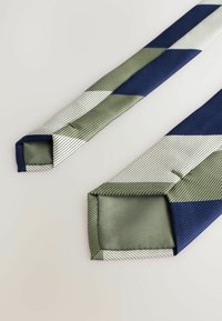 Mehrfarbige Krawatte mit geometrischem Muster in Marineblau, Grün und Weiß. Hergestellt aus geripptem Stoff mit schrägen Enden.