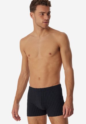 Boxer a quadretti neri con una texture morbida e una cintura elastica, caratterizzati da un motivo a griglia con accenti blu e bianchi.