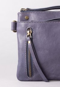 Purple leather handbag featuring a zip pocket with gold hardware and decorative stitching. Smooth texture with a minimalist design.
