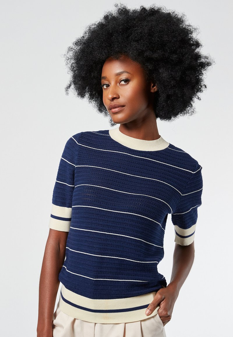 Navy short-sleeve sweater with white horizontal stripes, ribbed collar and cuffs, textured knit design, fitted silhouette.