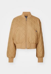 Chaqueta bomber corta de color beige con un patrón de rombos acolchado, cierre de cremallera, puños acanalados y dobladillo ajustado. Presenta una pequeña etiqueta de la marca en el lateral.