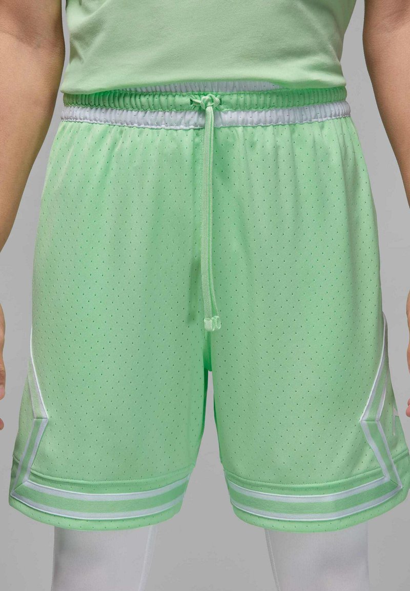 Bermudas deportivas de color verde claro con textura de malla, cintura elástica, cordón ajustable y detalles en blanco a lo largo del dobladillo y los costados.