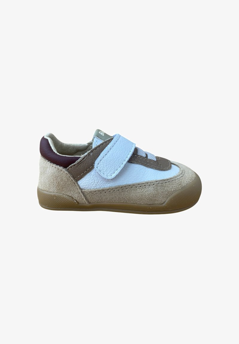 Zapatilla infantil de ante beige, cuero blanco y marrón, suela marrón y correa de Velcro azul claro, aislada sobre fondo blanco.