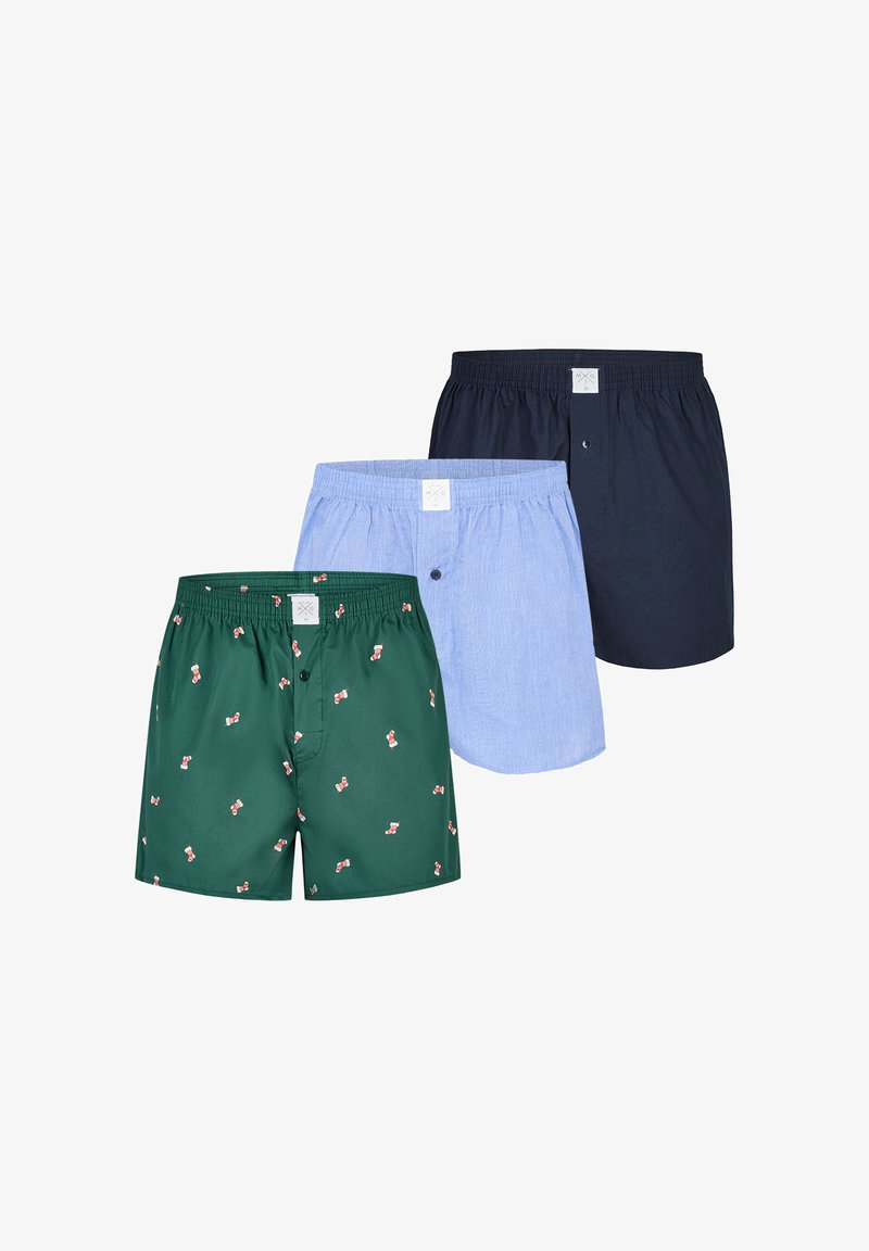 Drie paar herenshortjes: groen met rood strikjespatroon, lichtblauw gestreept stof en effen donkerblauw. Allemaal met elastische taillebanden.