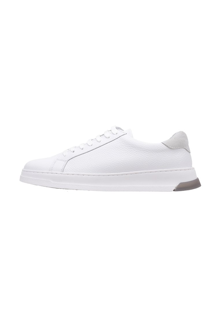 Zapatilla de cuero blanca con textura suave, que presenta una puntera redondeada, seis ojetes, un acento en el talón gris y una suela blanca resistente.