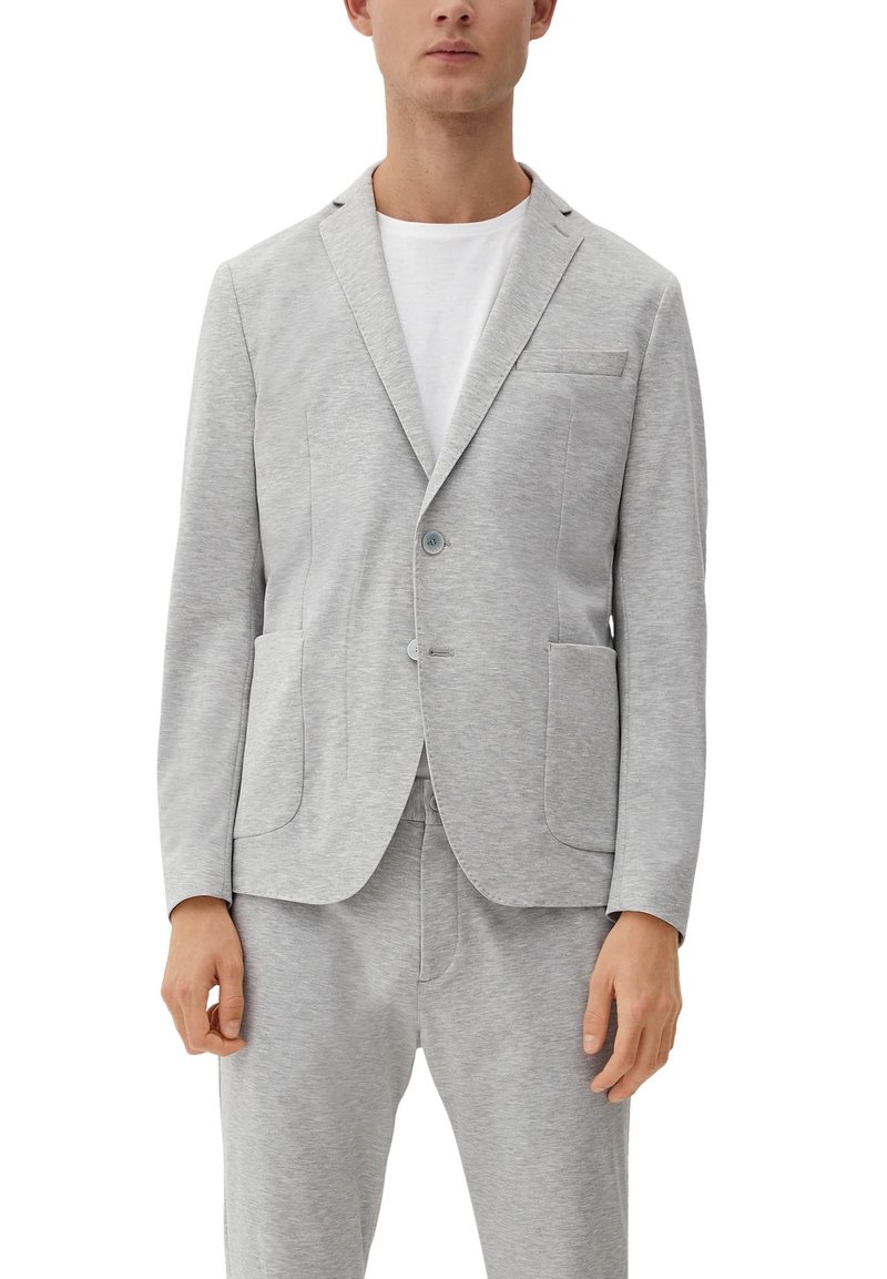 Lichtgrijze blazer van zacht materiaal, met notch-lapels, twee voorkokers en een enkele knoopsluiting, gecombineerd met bijpassende broeken.
