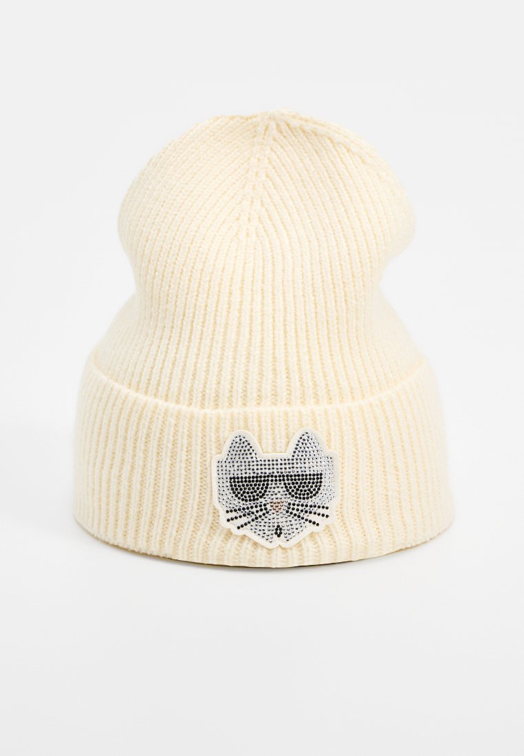 Cremfarbener, gerippter Strickbeanie mit umgeschlagenem Bündchen, das auf der Vorderseite ein Katzen Gesichtspatch mit schwarzen Sonnenbrillen zeigt.