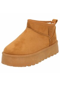 Tan suède enkellaarzen met een gestructureerde buitenzool, ronde neus en trekband aan de achterkant. Zachte binnenvoering voor extra comfort.
