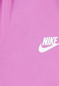 Rosa Baumwoll-T-Shirt mit glatter Textur und einem auffälligen weißen Nike-Logo auf der Vorderseite, ausgestattet mit einem klassischen Rundhalsausschnitt.