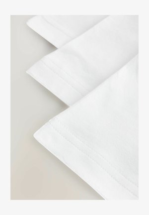 Biela bavlnená tkanina s rebrovanými manžetami, s hladkou textúrou a úhľadne prešitými okrajmi, zložená v vrstvách.