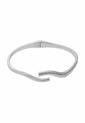 Bracciale aperto in argento con estremità curva decorata con piccole pietre scintillanti e la scritta "JETTE" incisa all'interno.