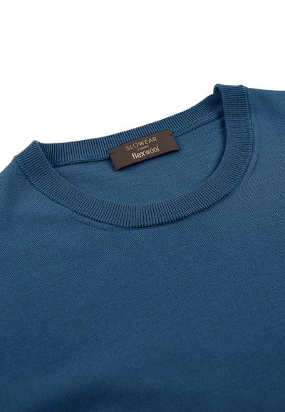 Maglione blu in tessuto Flexwool, con collo a giro e polsini a coste, dalla texture liscia e un'etichetta che recita "Slowear Flexwool."