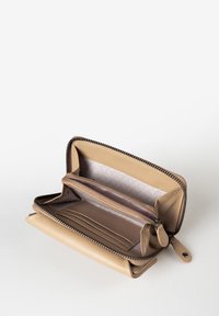 Beige leren portemonnee met een ritssluiting, voorzien van meerdere kaartsleuven, een groot vak en een gestructureerde binnenvoering.