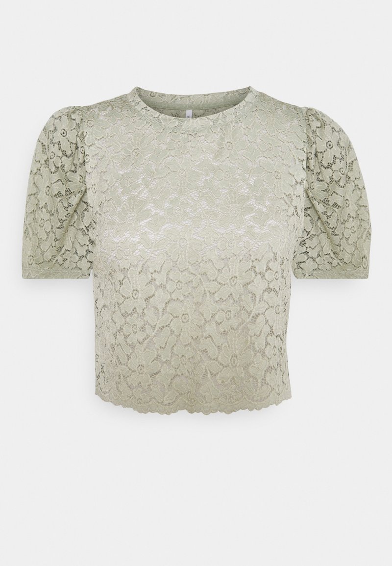 Blouse en dentelle vert clair à motif floral, manches courtes bouffantes, encolure ronde, et ourlet festonné.