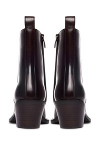 Bottines en cuir marron avec une finition brillante, talon carré, zips latéraux et tirants en boucle. Présente des lignes épurées et un minimum de coutures.