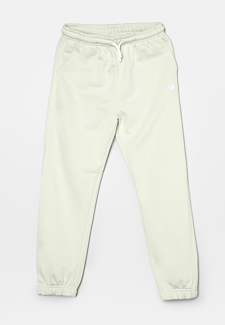 Pantaloni da tuta New Balance di un beige chiaro con cintura elastica, lacci, tasche laterali e polsini elasticizzati.