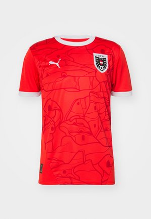 Červený futbalový dres vyrobený z priedušnej látky, so abstraktným vzorom a bielym golierom. Obsahuje logo Puma a emblém národného tímu.